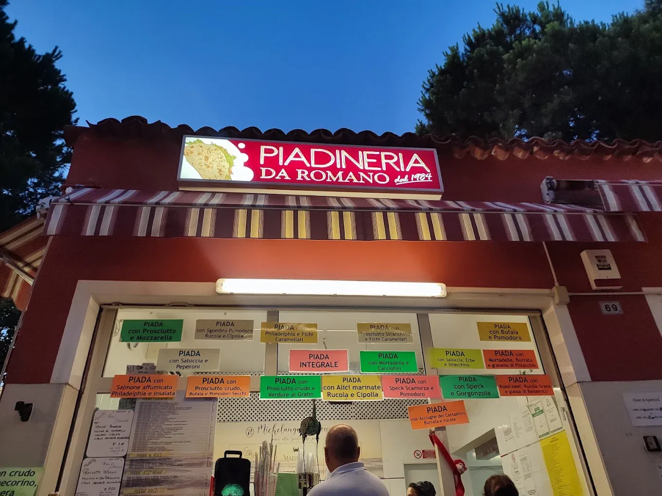 L'insegna del chiosco al crepuscolo con i cartellini dei gusti